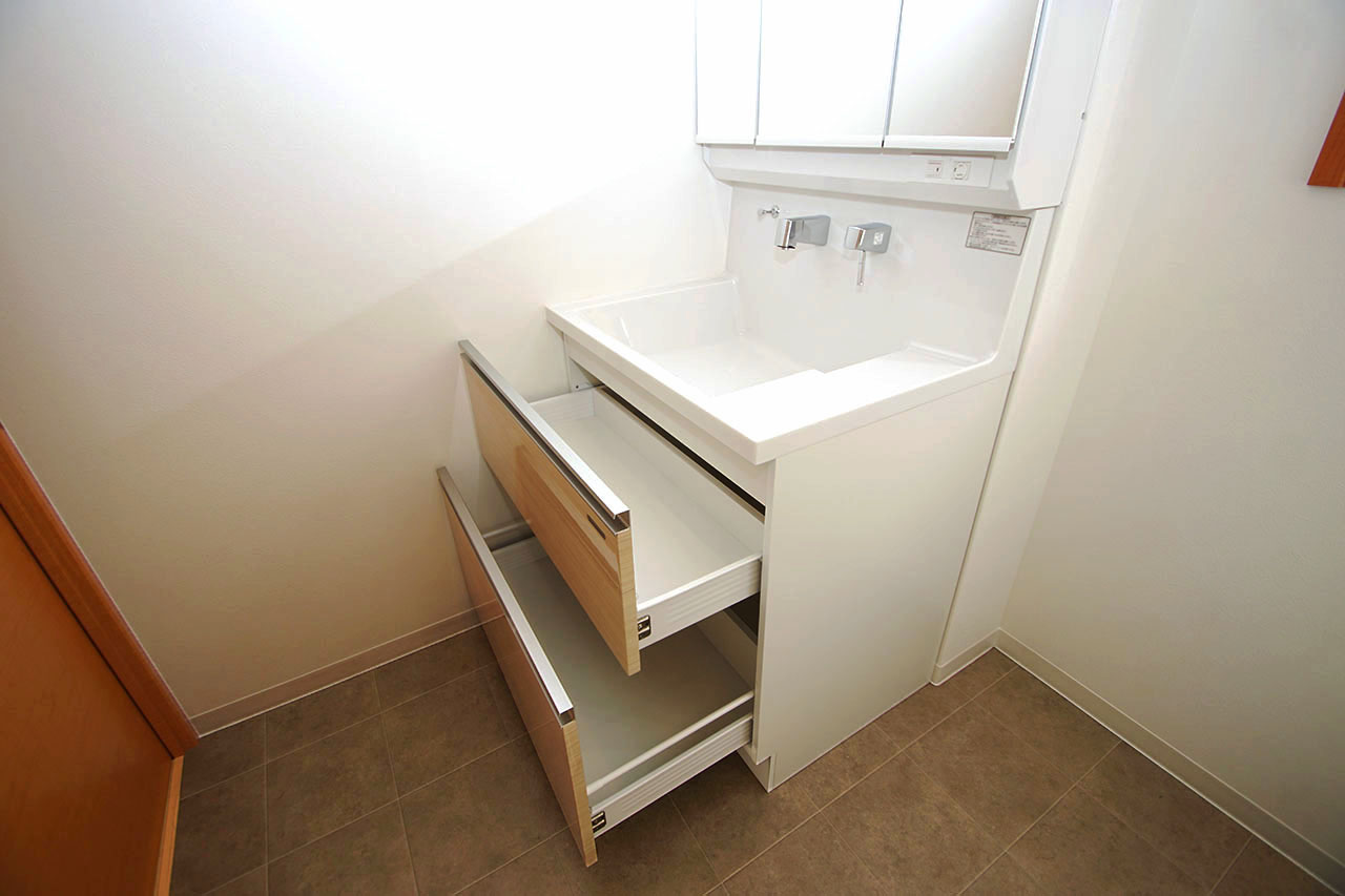 洗面台の収納は便利なスライドタイプ。中の物を見やすく仕分けもしやすい収納です。