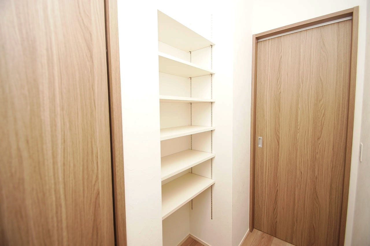 廊下のクロゼット横に設置された可動棚。見せる収納としておしゃれにディスプレイを楽しめます。