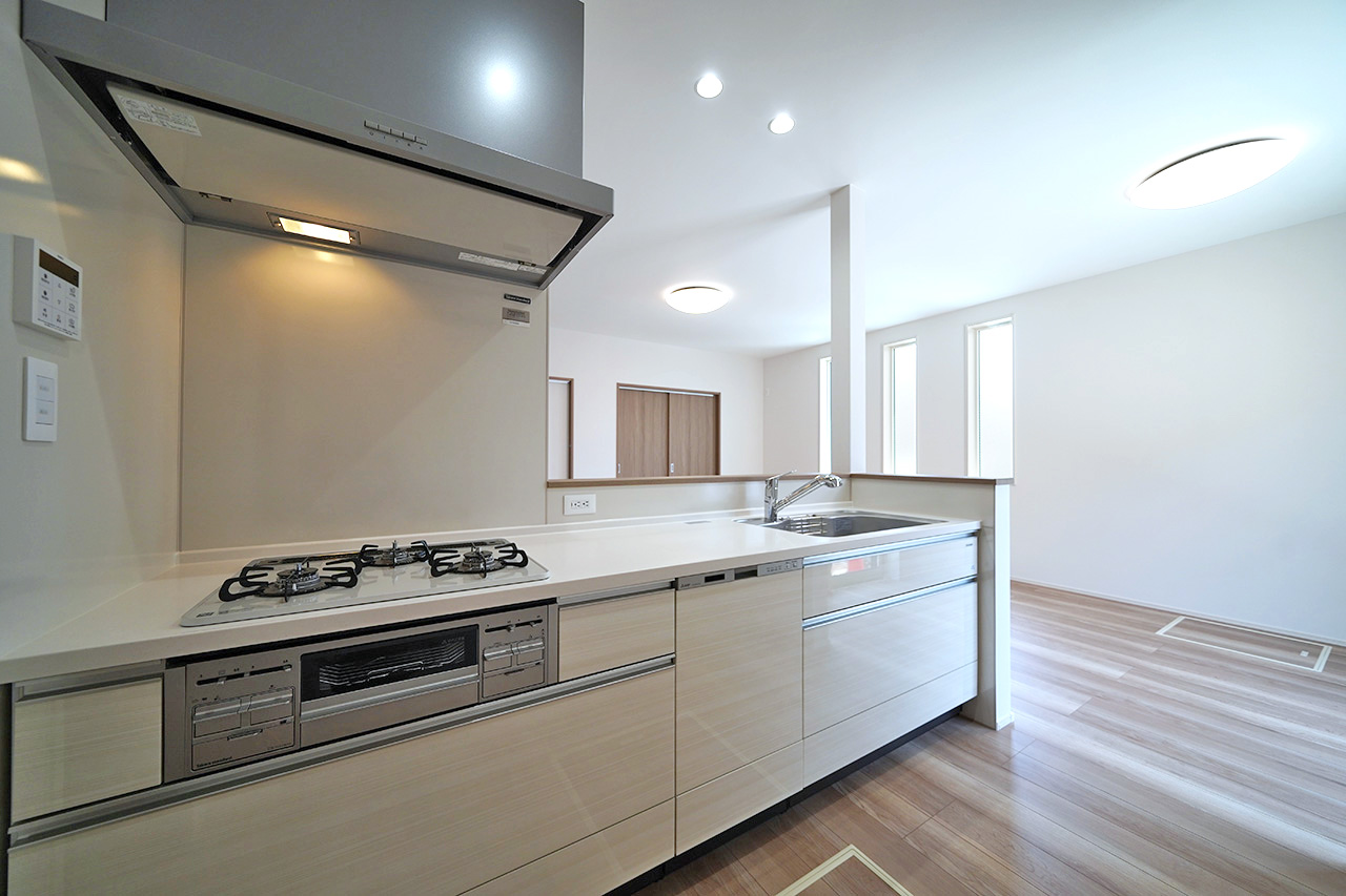 清潔感のあるホワイトカラーのシステムキッチン。リビングを一望できるオープンタイプのキッチンです。