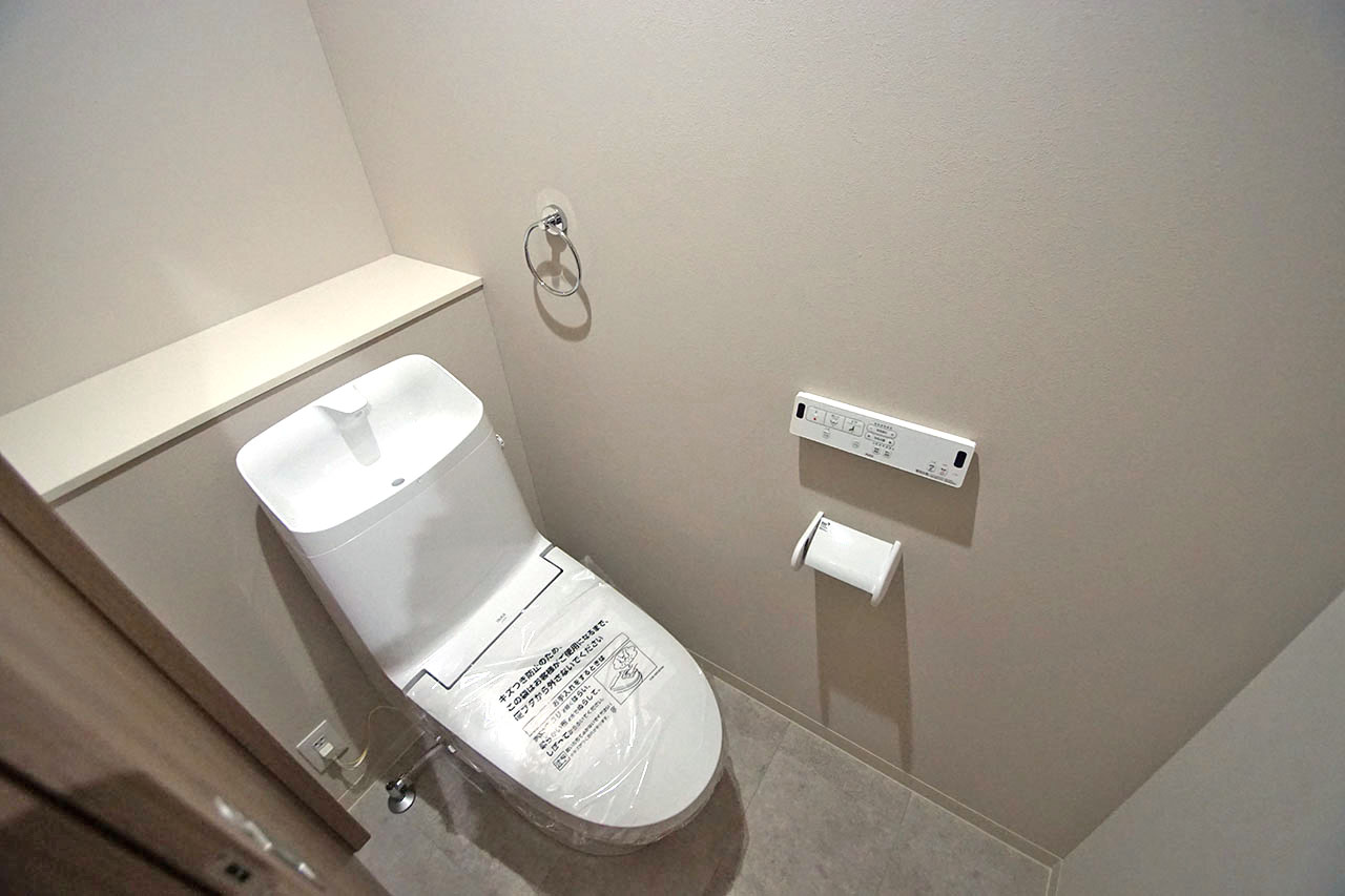 トイレ。ライトベージュのクロスで落ち着きのある空間に。