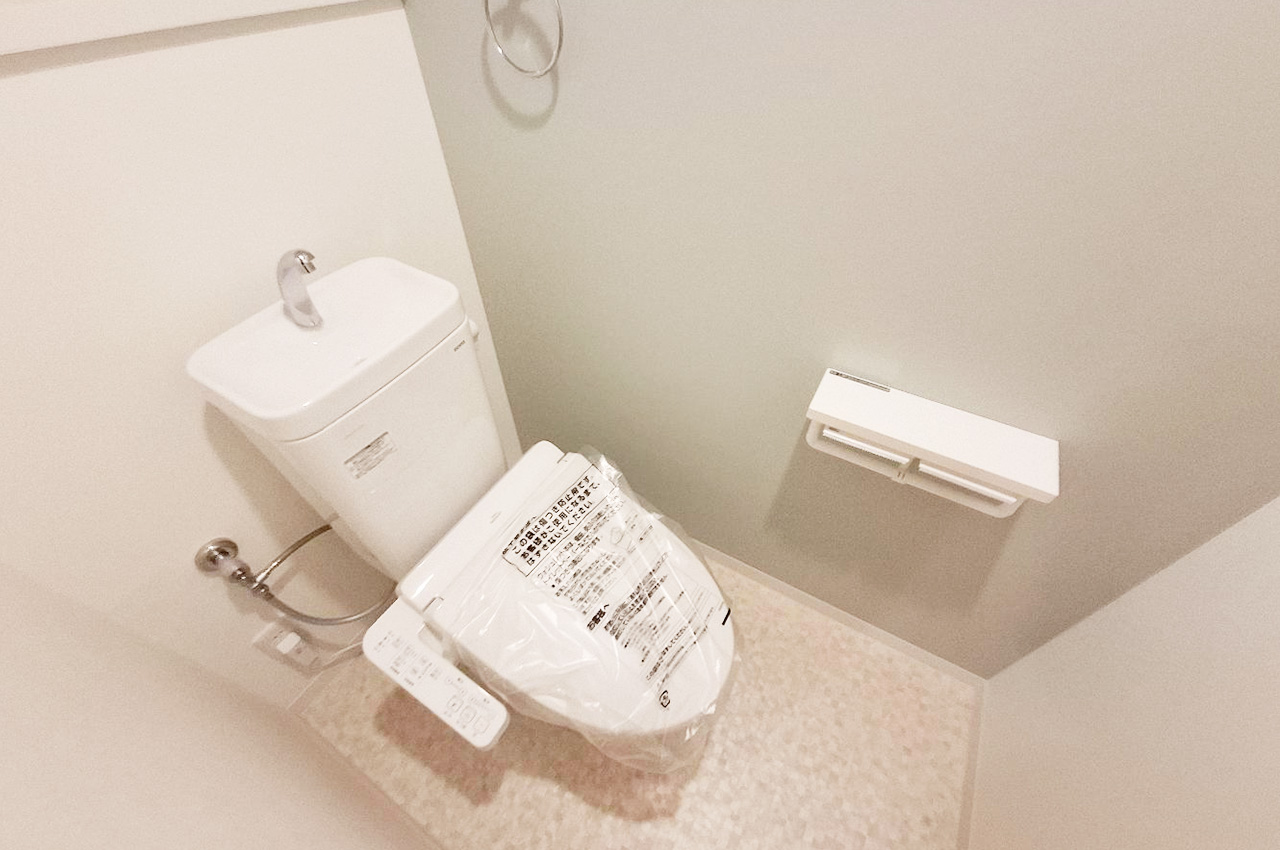 トイレ:新調済みの温水洗浄便座を備えた清潔感溢れるトイレ。張り替えたブルーグリーンのクロスが爽やか。