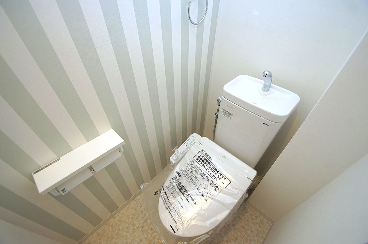 トイレ内もピカピカにリフォーム済み。壁一部には爽やかなストライプのアクセントクロスを貼りました。