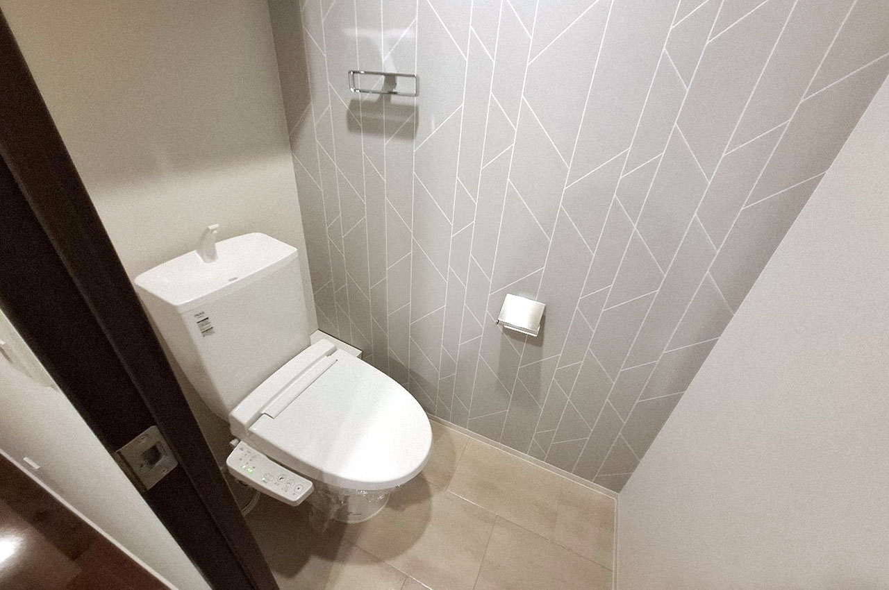 北欧風のアクセントクロスが印象的な、清潔感のあるトイレスペース。