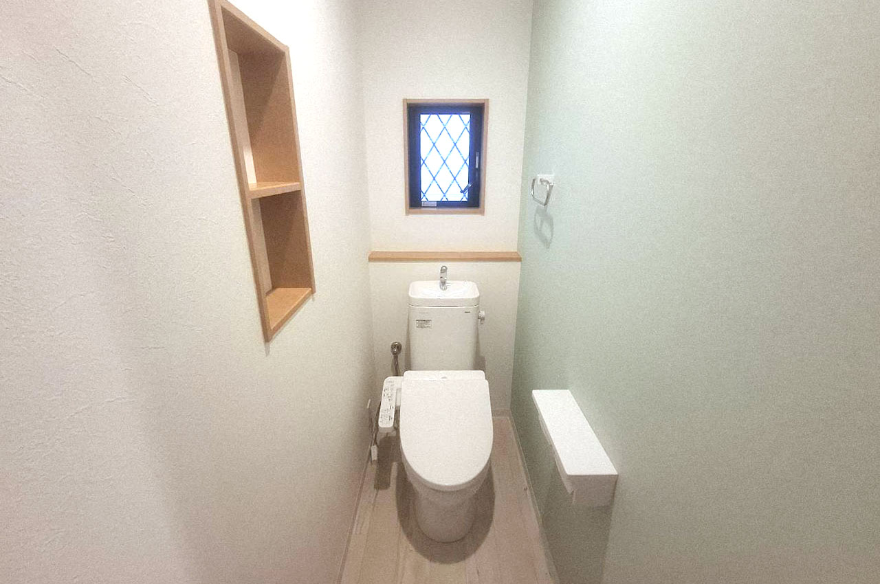 トイレ内もピカピカにリフォーム。爽やかなグリーンのアクセントクロスを施しました。