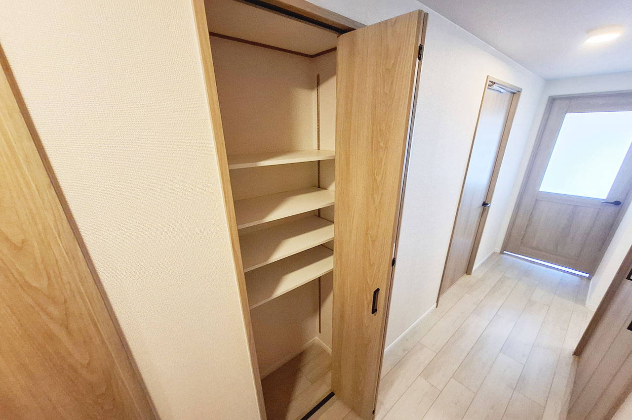 廊下に設置された可動棚付きの物入。コンパクトながら実用性の高い収納スペースです。