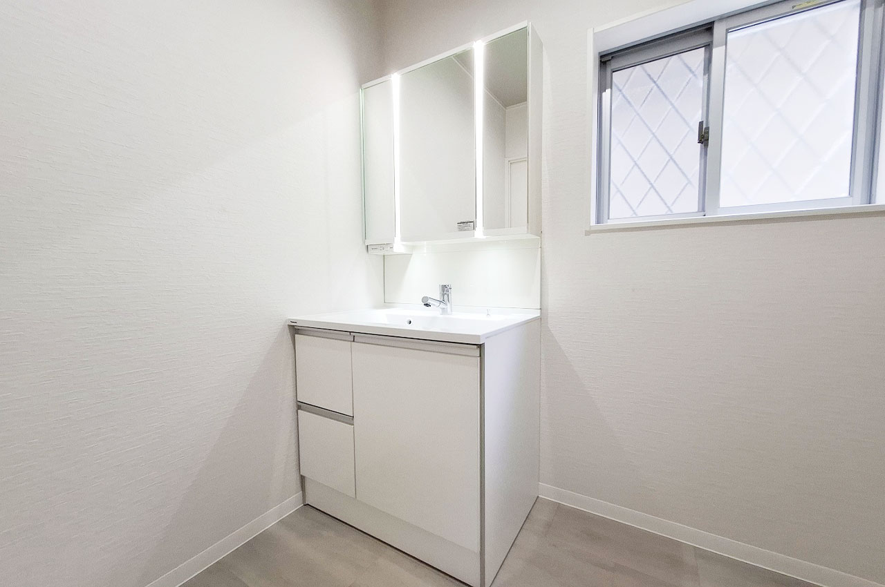 シンプルで明るい洗面室。中が見やすいスライド収納や鏡面裏収納付きで使い勝手の良い洗面化粧台が魅力。