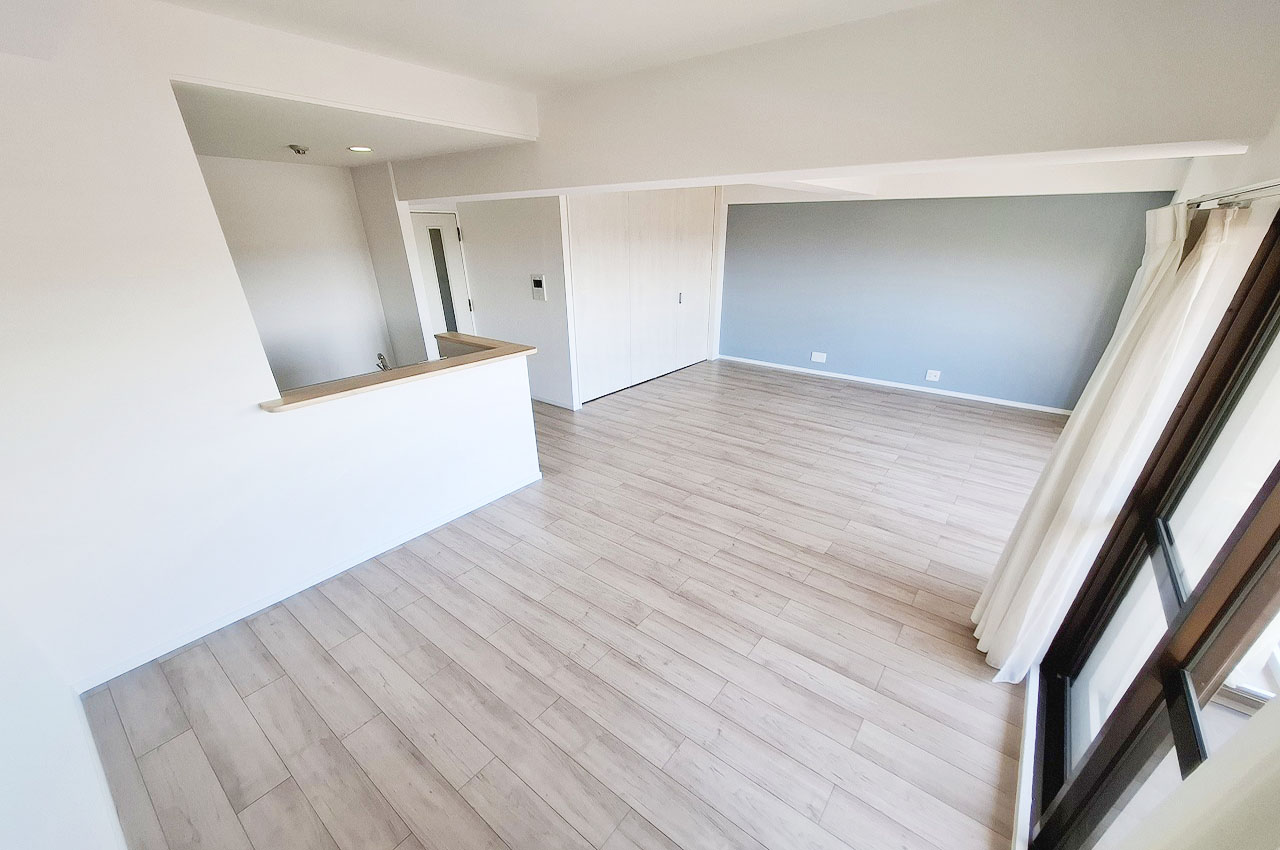 アッシュ系のライトなフローリングと爽やかなブルー系のアクセントクロスで仕上げたリビングダイニング