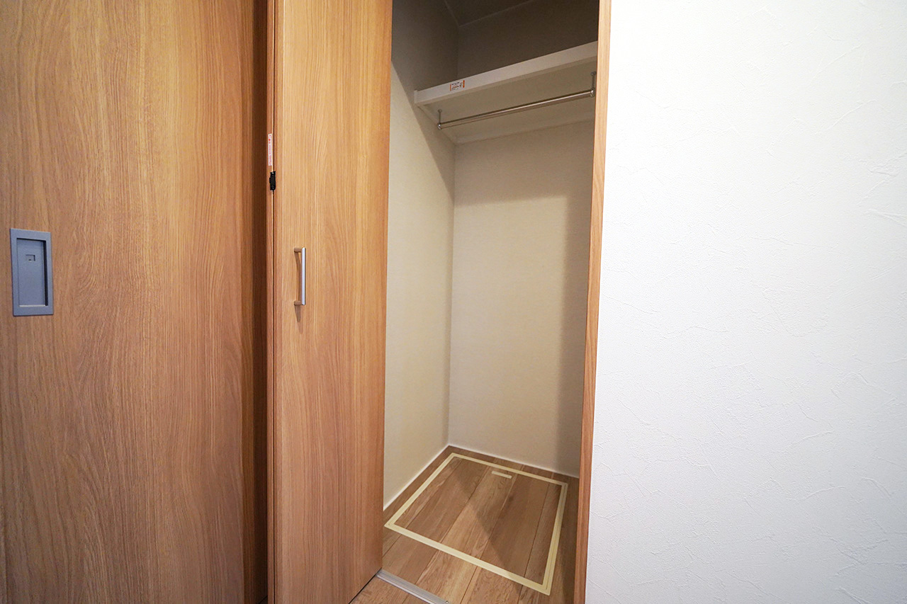 ホールのシステム収納。外出や帰宅時にコートや上着をさっと掛けられるアウター収納に便利。