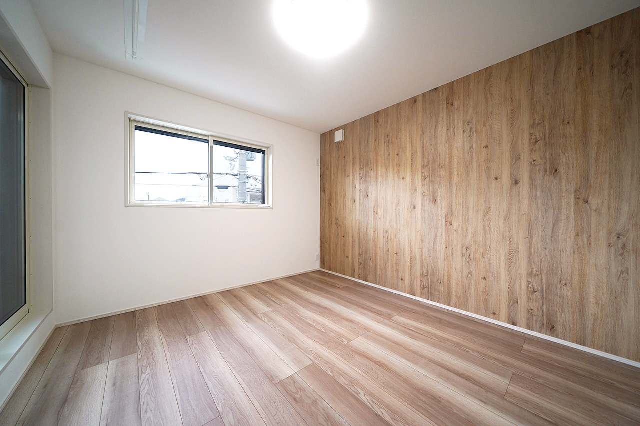 洋室（1）7帖：木目調のアクセントクロスが温かみのある空間を演出。