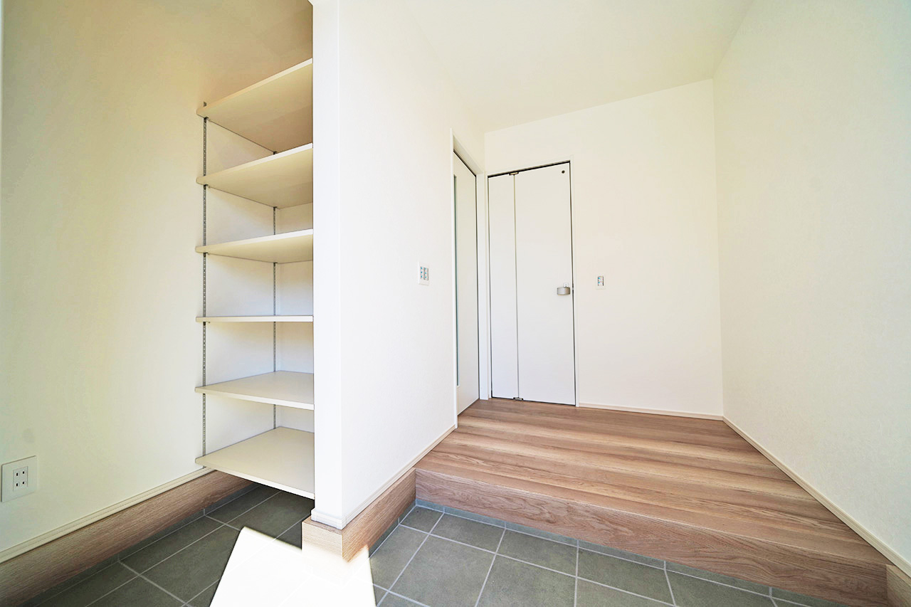 靴だけでなく傘やベビーカーも収納可能なシューズクロークで、生活感を抑えた玄関が実現。