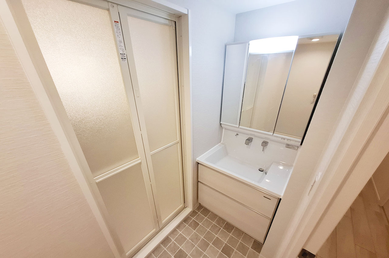 洗面室：洗面室内はリフォームで一新。新調した三面鏡付き洗面化粧台でメイクや身支度もスムーズに。