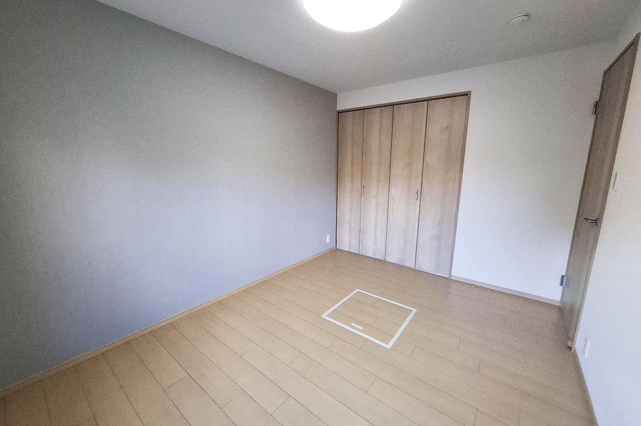 洋室約6帖の壁一部には、落ち着きのあるグレーのアクセントクロスを貼りました。