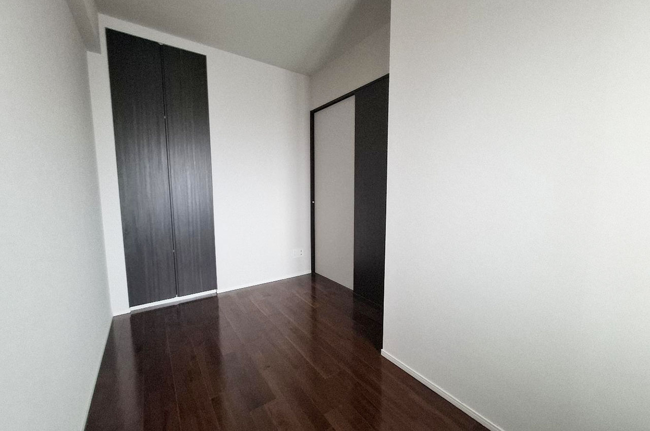 約5帖の洋室②。シンプルな内装とダークトーンの建具が落ち着きを演出します。