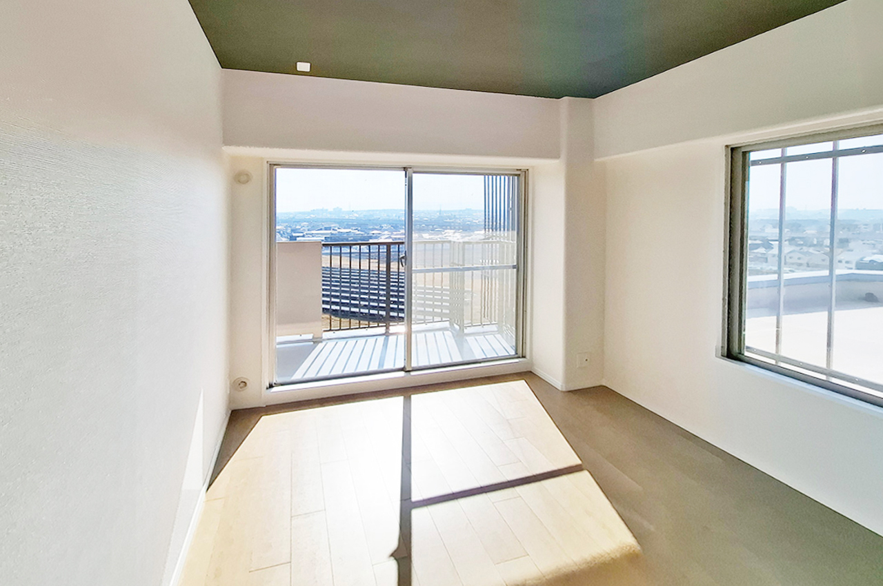 洋室1：天井には落ち着いた色のアクセントクロスを施しました。