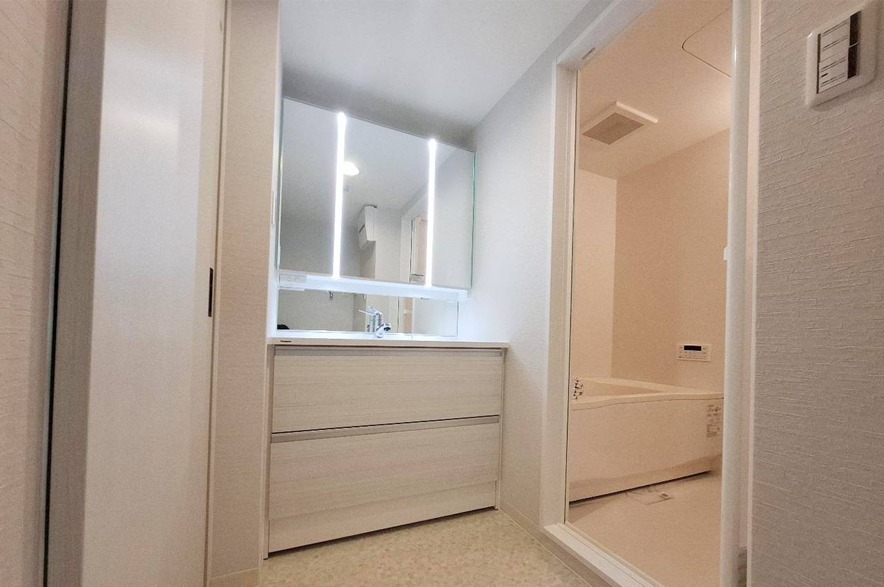洗面室内はリフォームで一新。新調したワイドな三面鏡付き洗面化粧台でメイクや身支度もスムーズに。