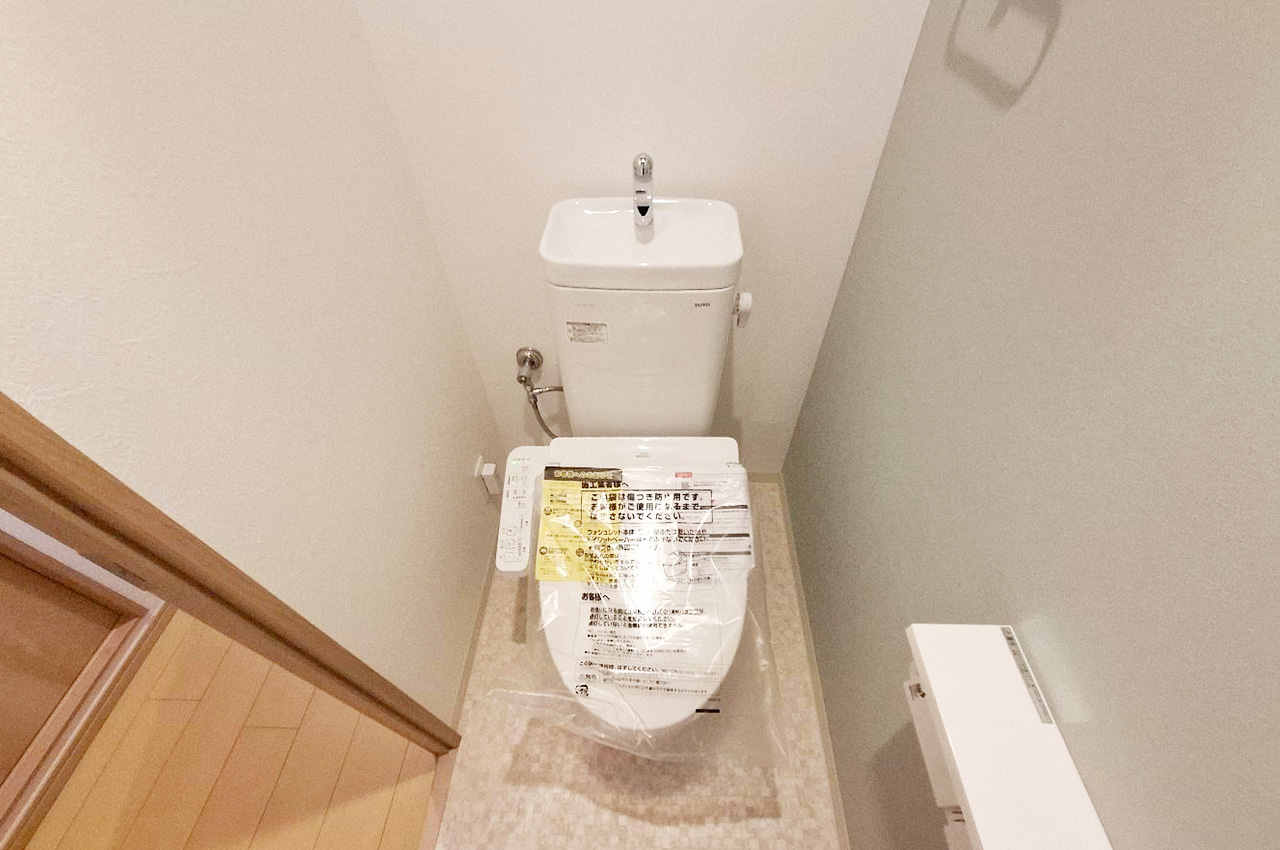 トイレ:新調した便器と温水洗浄便座で新生活を気持ちよくスタート。壁紙と床もリフォーム済み。
