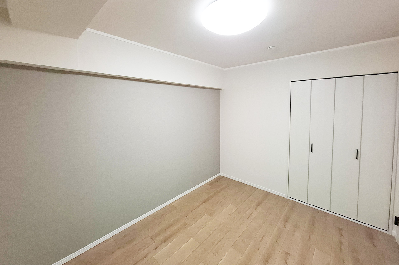 洋室1：落ち着いたグレーのアクセントクロスを新調済み。