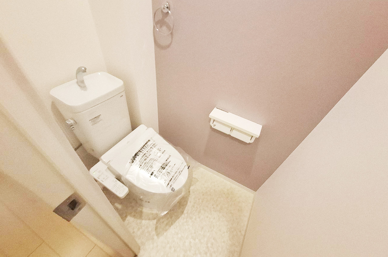 温水洗浄便座付きの新品トイレで清潔感あり。淡いカラーのクロスが落ち着いた空間を演出します。