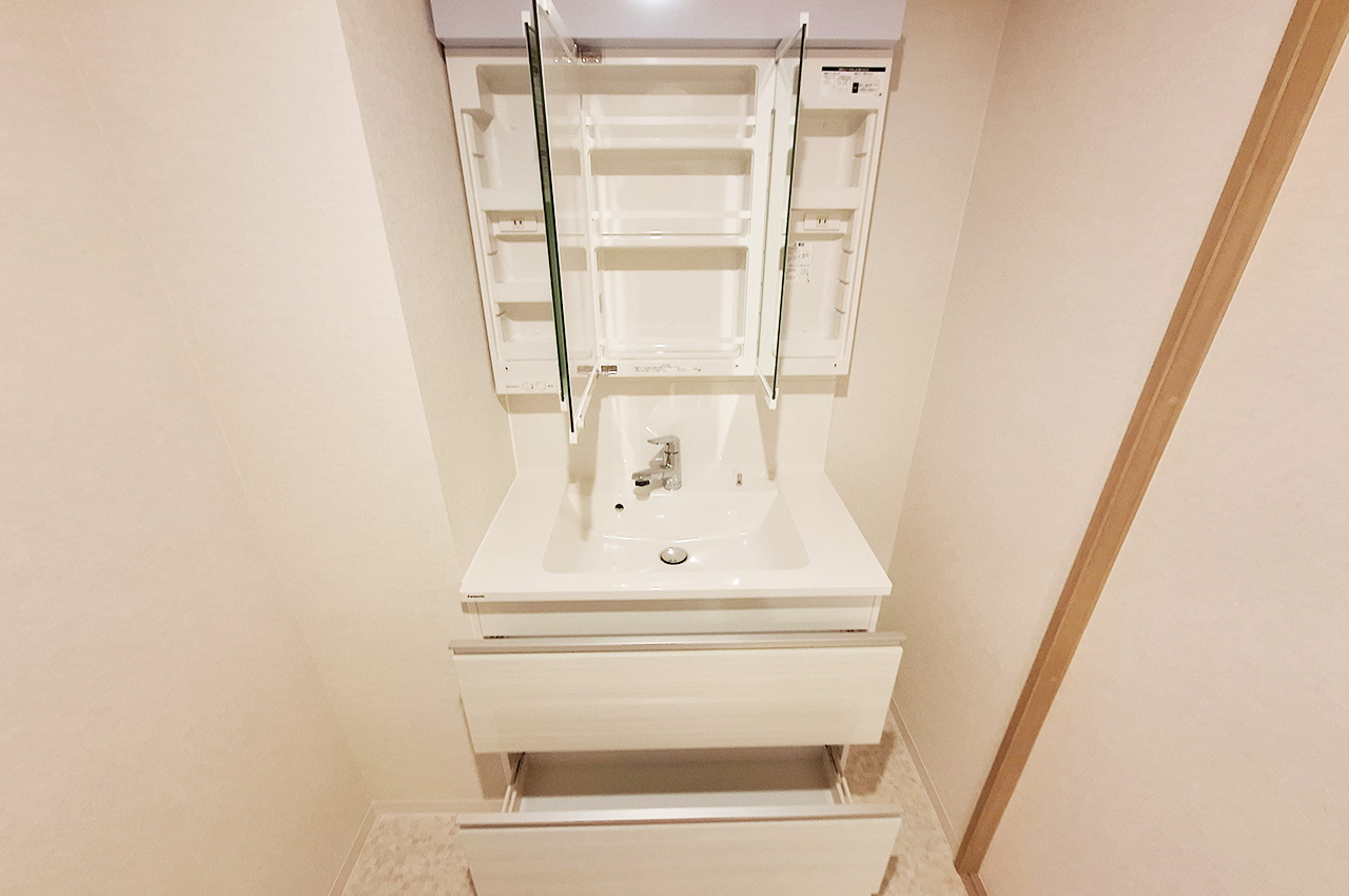 洗面室：新調した洗面化粧台はスライド収納付きで日用品をすっきりと片付けられます。